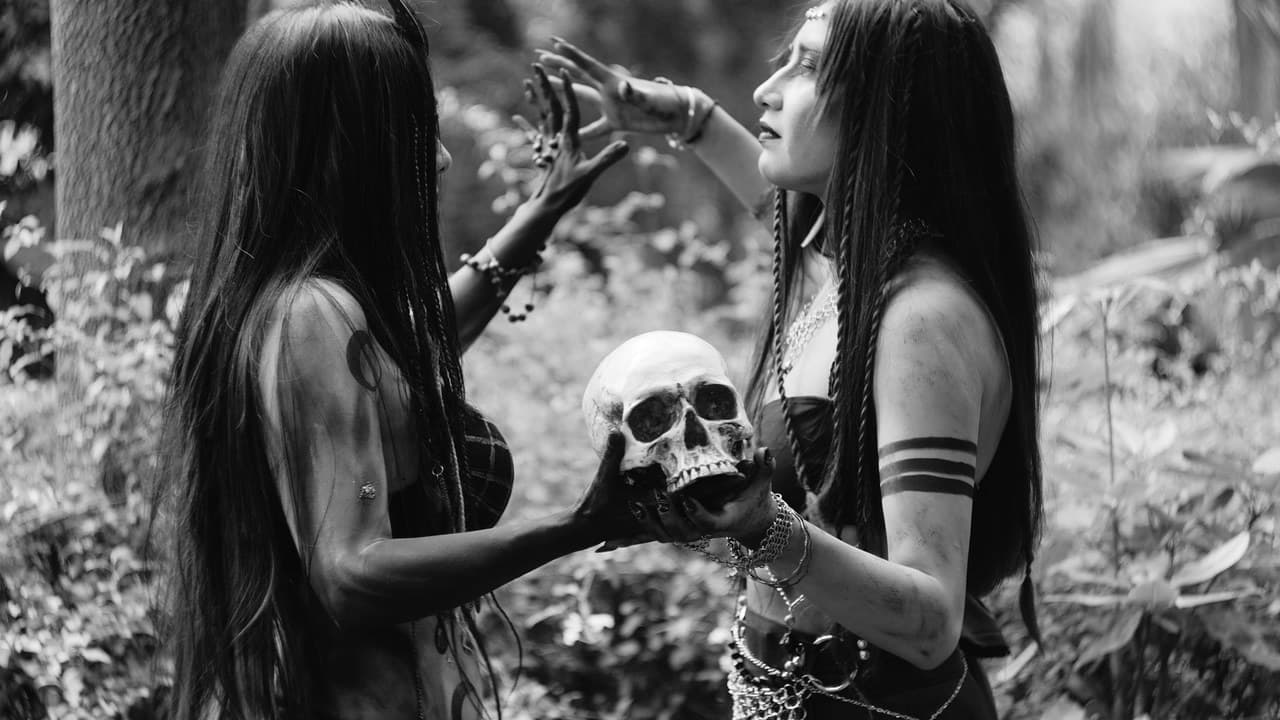 Two women engaged in a mystical ritual holding a skull in a forest.